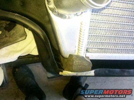 Radiator mounting bracket with rubber isolator and metal support