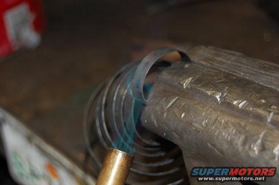 Metal coil heated in vise with torch