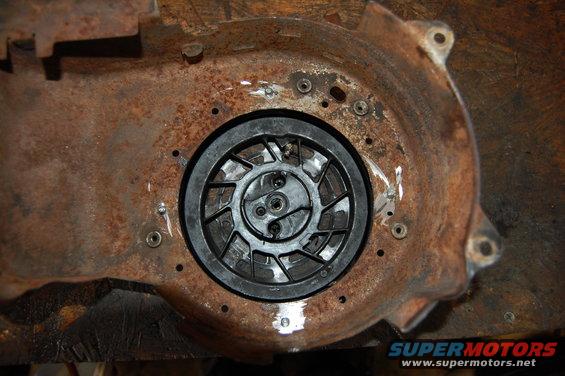 Rusty metal housing with a black plastic recoil starter assembly