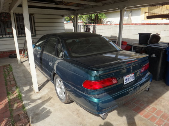 Dark green 1993 Ford Taurus sedan, rear view, California license plate 6MDH980