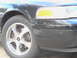 2007 Ford Crown Victoria - Close-up of the front fender, headlight, and wheel of a black 2007 Ford Crown Victoria.