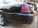 2007 Ford Crown Victoria - The rear of a black sedan is shown, a spoiler and distinctive taillights.