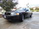 2007 Ford Crown Victoria - A black 2007 Ford Crown Victoria is parked on a driveway in front of a residential house.