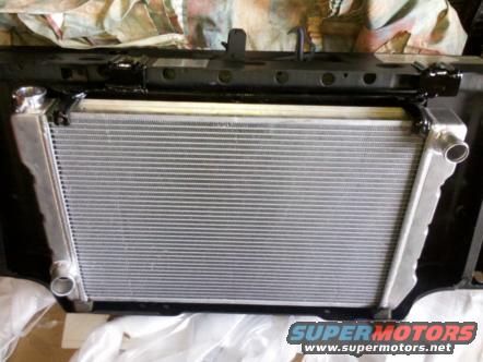 Radiator assembly with silver fins and aluminum tanks, mounted in black frame