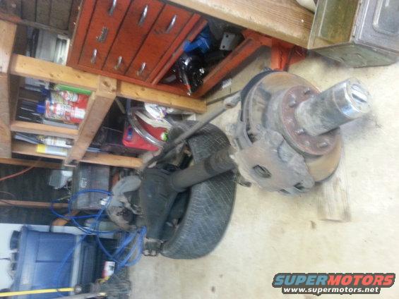 Vehicle axle with brake rotor and caliper, plus a tire