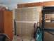 1964 Ford Fairlane - A cluttered garage scene shows a tall wooden cabinet, various tools including a sledgehammer and jacks, and a wall with visible drywall rep…
