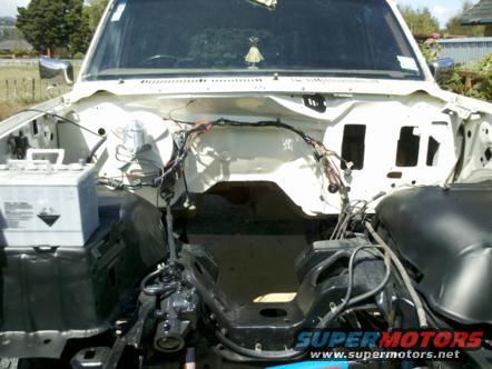 1982 Ford Bronco engine bay with battery and wiring visible