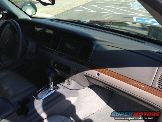 Interior shot of a Crown Victoria showing the dashboard, steering wheel, gear shifter, and passenger side trim
