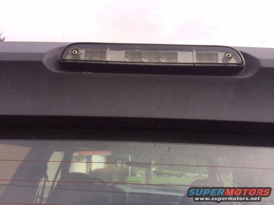 Close-up of a vehicle's third brake light assembly mounted above the rear window
