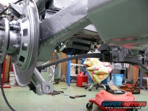 Rear suspension and frame of a car with a red SuperMotors logo visible