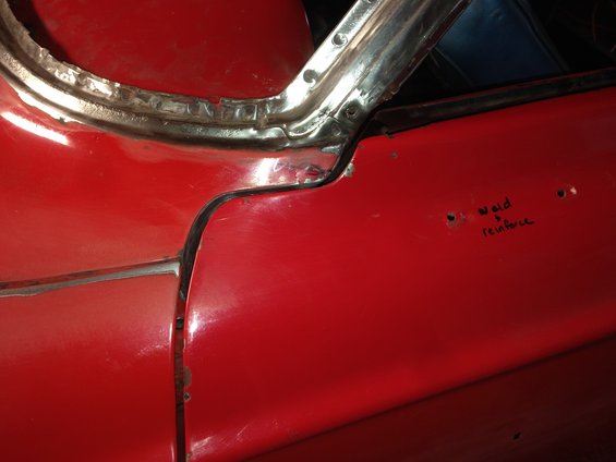 Red car door frame with visible weld marks and handwritten text 'weld & reinforce'