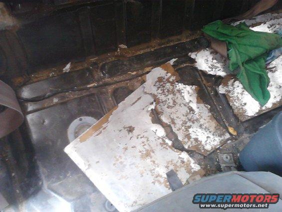 Interior of a vehicle with peeling paint and debris, possibly during restoration