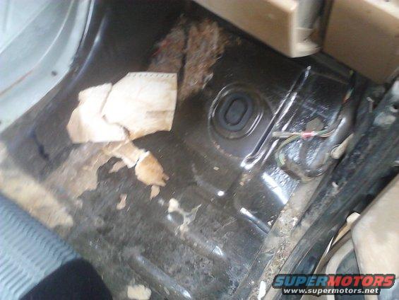 Interior floor with torn carpet and exposed metal