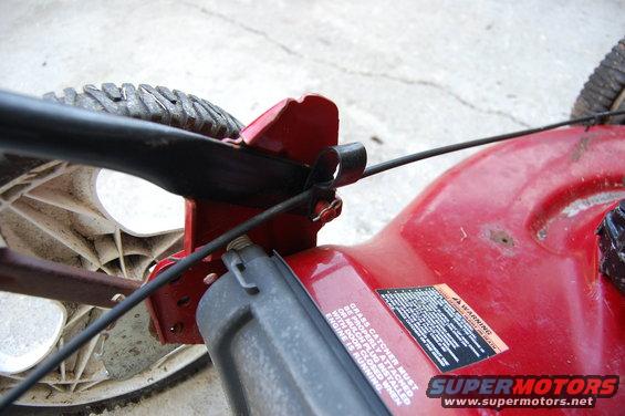 Close-up of red lawn mower deck with wheel and handle attachment