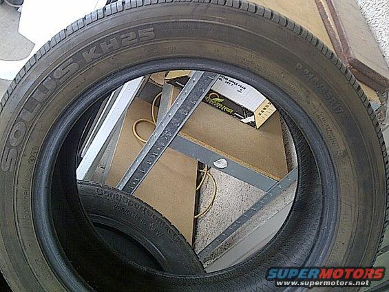 Tire with Solus KH25 and Continental ContiSportContact markings, inside a metal rack