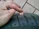 1993 Ford Probe - Checking tire tread depth with a penny. The tire has visible tread wear indicators.