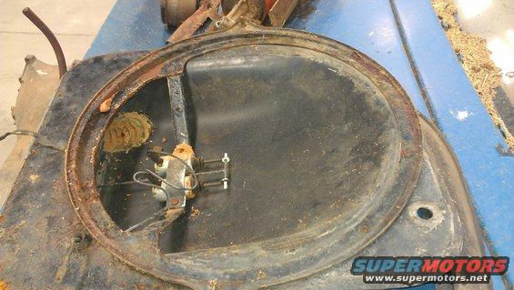Rusted fan shroud with electric motor and wiring. Shows signs of wear and tear