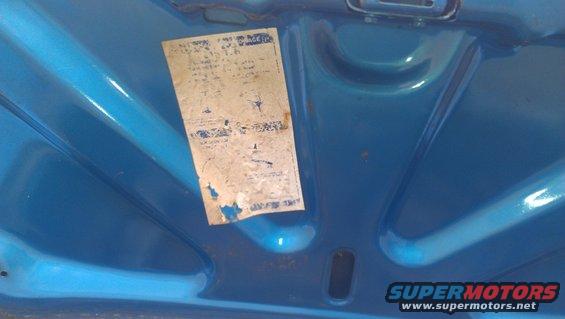 Underhood sticker on a blue painted surface. Text on sticker is faded and torn