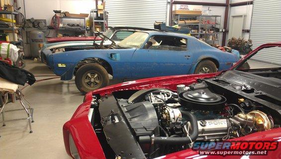 Blue 1970 Pontiac Trans Am in a garage, hood open, front quarter view