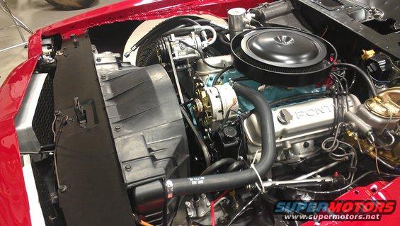 Pontiac V8 engine bay with air cleaner, alternator, and radiator visible. 'PONTIAC' stamped on valve cover