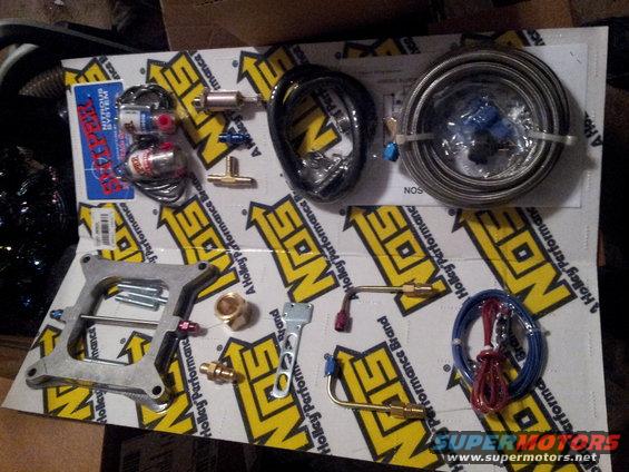 NOS Nitrous Oxide System parts including bottles, lines, and a carburetor plate