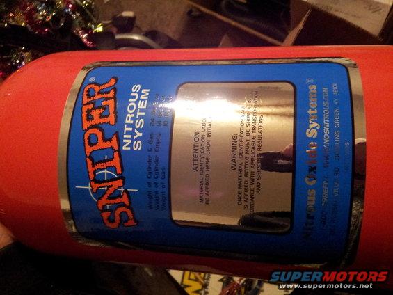 Red nitrous oxide bottle with a blue Sniper Nitrous System label. Label includes warnings and specifications