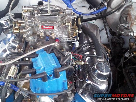 Close-up of a V8 engine showing an Edelbrock carburetor and blue distributor cap