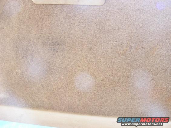 Tan headliner with light stains and a light-colored trim piece at the top