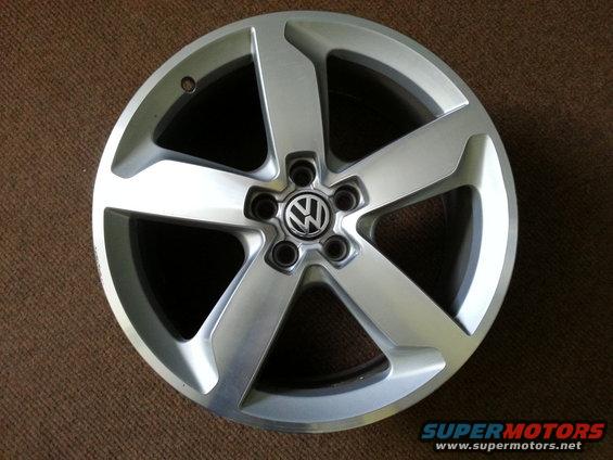 Silver Volkswagen wheel with five spokes and a central VW logo