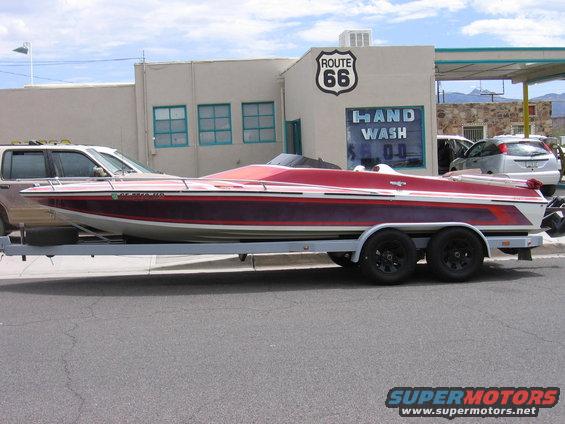 Red and white speed boat on a trailer, side view