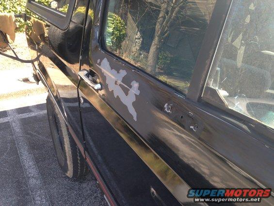 Black SUV side door with peeling paint and visible door handle