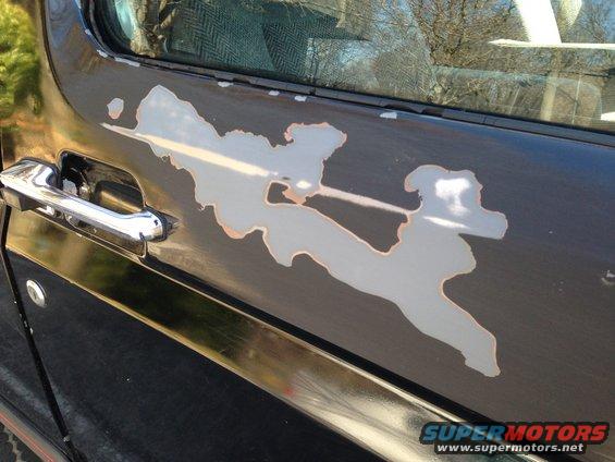 1990 Ford Bronco side door with peeling black paint revealing primer