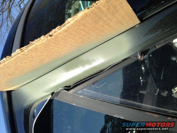 Black vehicle window frame covered with cardboard