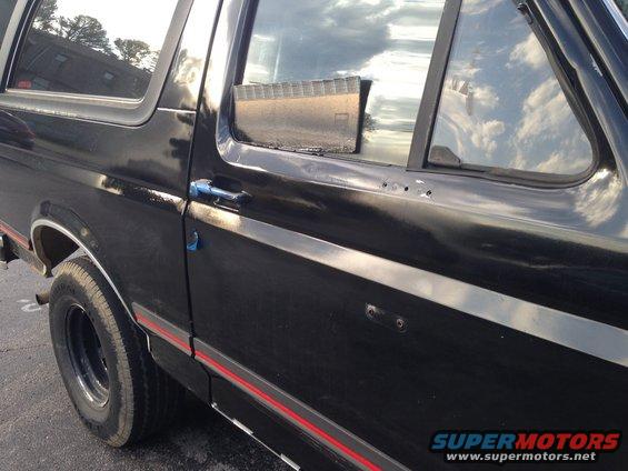 Black SUV side door with chrome trim and red stripe