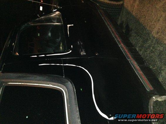 Black SUV roof and side window with white pinstriping detail