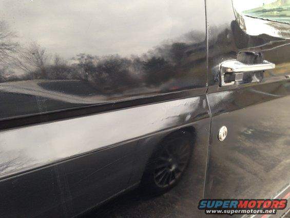side of a black SUV, showing door handle and wheel