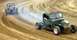 1969 Lincoln Continental - Two custom hot rods race on a dusty dirt track, kicking up dust as they corner.