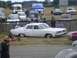 1969 Lincoln Continental - A white 1959 sedan with a distinctive chrome grille and lowered stance is parked on grass.