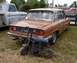 1969 Lincoln Continental - A brown sedan, likely from the 1970s, is parked next to a pickup truck with a mini bike in front of its rear bumper.