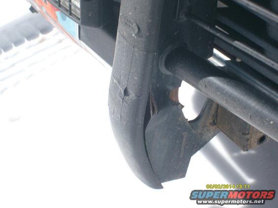 Damaged front bumper corner of a 1991 Land Rover Range Rover, showing a cracked plastic section and part of the grille