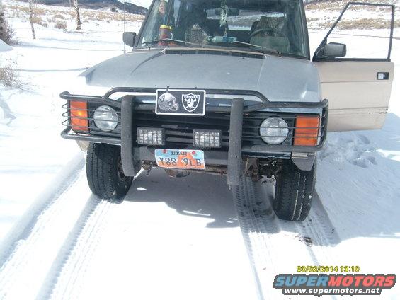Front view of a 1991 Land Rover Range Rover in the snow. It has a bull bar and auxiliary lights