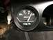 1964 Ford Ranchero - A close-up view of a black Auto Gage voltmeter gauge with white markings and a needle indicating 15 volts.