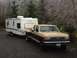 1988 Ford F-350 - A Ford pickup truck tows a travel trailer in a wooded area with icy trees.