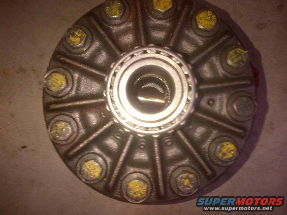 Differential cover with yellow-capped bolts and a bearing