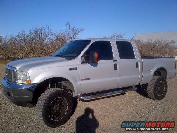 Silver Ford F-250 Super Duty pickup truck, lifted with aftermarket wheels