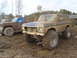 1978 Ford Bronco - Two off-road vehicles, a 1978 Ford Bronco and a pickup truck, sit in a muddy area.