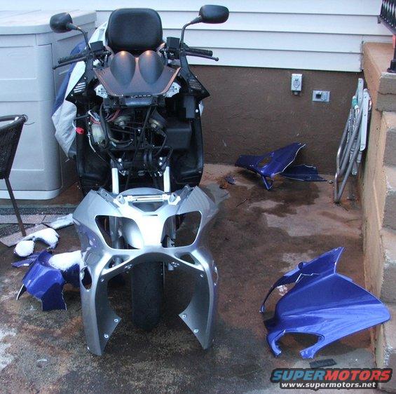 Scooter disassembled with fairing pieces on the ground