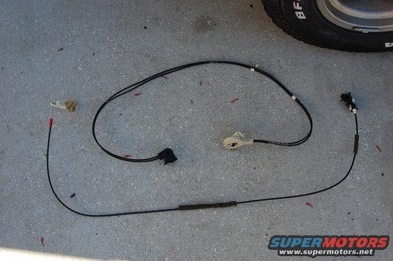 Door latch cable assembly with two connectors and a rubber boot