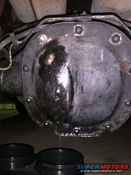 Differential cover with fluid leaking into black containers below