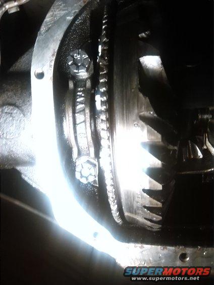 Differential gears with bolts and a chain visible inside a metal housing